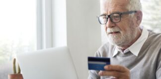 Starszy mężczyzna używający karty płatniczej